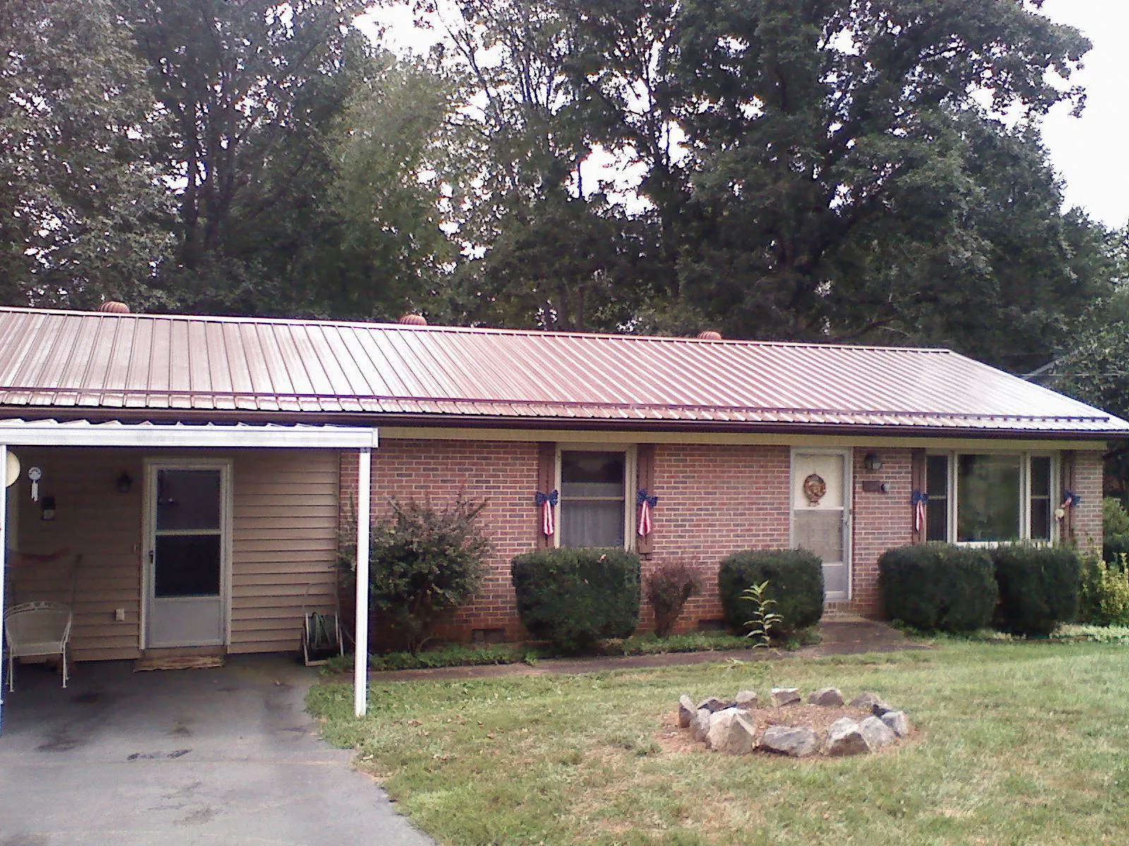 Bronze metal roof and carport on a brick ranch home — Roof Repair work by our crew in Dickson